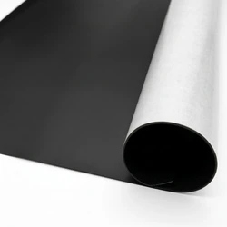 Folia magnetyczna w rolce pokazująca czarną stronę magnetyczną oraz białą warstwę samoprzylepną z klejem