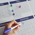 Tablica magnetyczna suchościeralna z kalendarzem rocznym, kolorowymi magnesami i ręką piszącą markerem