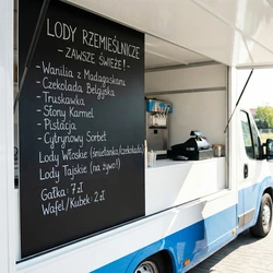Zewnętrzna tablica kredowa z przykładowym nadrukiem menu lodziarni zamontowana na boku food trucka